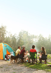 Les gens se reposent près de la tente de camping en pleine nature