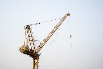 Industrial landscape with silhouettes of cranes on the sunset background