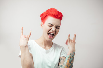 emotional glamour girl making a rock-n-roll sign. rock fan is shouting. cool hipster girl is...