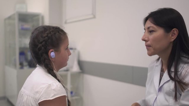 Nurse examines the ear of a girl