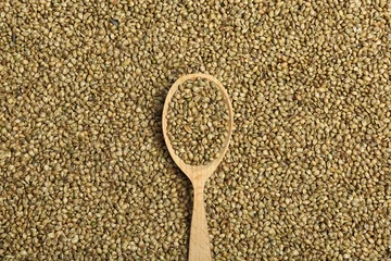 Rolgordijnen Wooden spoon and hemp seeds, top view © New Africa