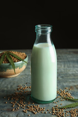 Bottle of hemp milk on wooden table