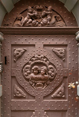 Angels on metal door, small sculptures on facade of historical home