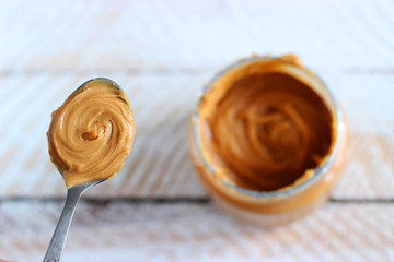 peanut butter in a spoon on a light background