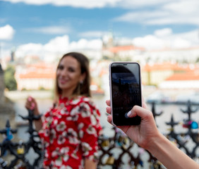 Beautiful brunette girl in red dress make a photo in Prague, city streets