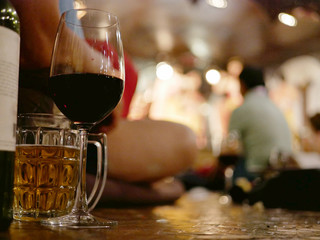 Glasses of wine and beer on the sitting floor in the mid of tourists coming to enjoy traditional NorthernThai performance and dinners, Chiang Mai, Thailand