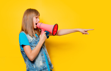portrait of young teenage girl with megaphone on yellow background