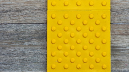 Top view of footpath tiles on a marble texture cover. Yellow circle buttons pattern. A stop signal...