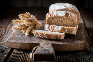 Tasty and fresh bread with grains on wooden table