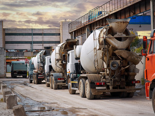 Heavy mixer concrete trucks waiting for to be loaded on the concrete mixing and batching factory....