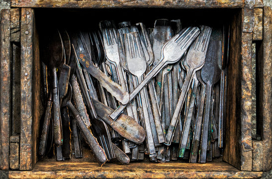 Work in process of handmade broze cutlery of spoons and forks in wooden box in bronze cutlery factory, image for industrial background
