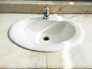 white bathroom washbasin with tap, plughole and plug