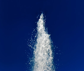 Water fountain against the dark blue sky