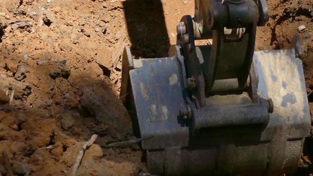Digging a trench with a backhoe - closeup