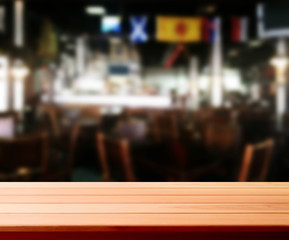 Wood table with blured background cafe , for your photo montage or product display. Space for placing items on the table.