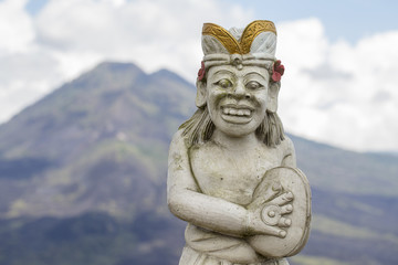 Fototapeta na wymiar Traditional Balinese sculpture against the background of the volcano Batur. Island Bali, Indonesia. Closeup