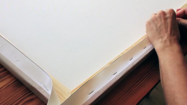 Stretching the canvas on a stretcher. The concept of printing photos on canvas.