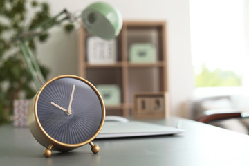 Stylish alarm clock on table in office. Time to work