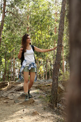 Naklejka na ściany i meble Young woman with backpack in forest on summer day. Camping season