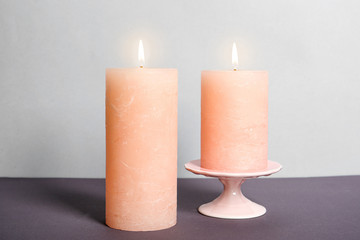 Fototapeta na wymiar Decorative wax candles on table against light background