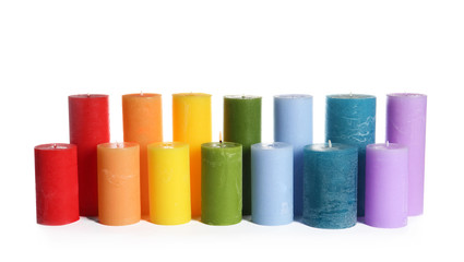 Different colorful wax candles on white background