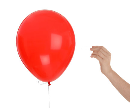 Woman piercing red balloon on white background