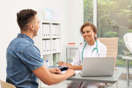 African American Doctor Working With Patient In Hospital