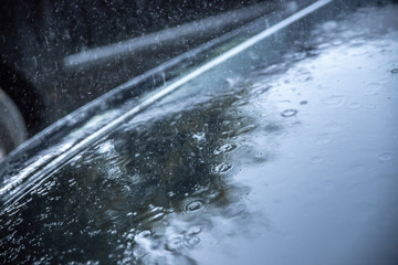 Regentropfen auf Autodach, Starkregen