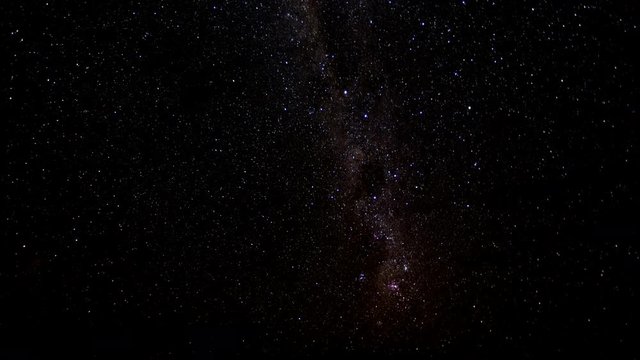 Milky Way moves through sky as some clouds pass over front