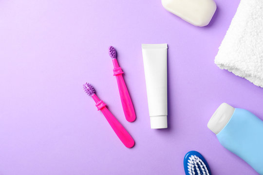 Flat lay composition with baby toothbrushes and toiletries on color background