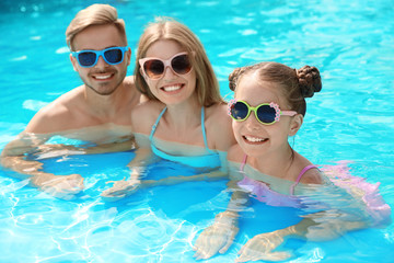 Happy family in pool on sunny day