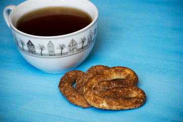 Poppy with pretzels on a blue board with a cup of tea. A cup of tea and pretzels with cinnamon.