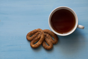 Poppy with pretzels on a blue board with a cup of tea. A cup of tea and pretzels with cinnamon.