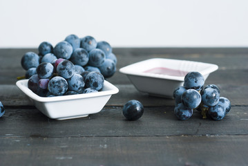 red grape juice in china bowl, black wood table background