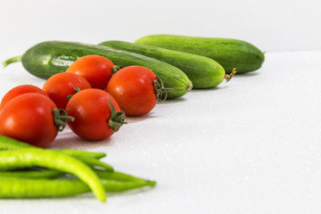 cucumber , green pepper and tomato on white background . healthy life concept