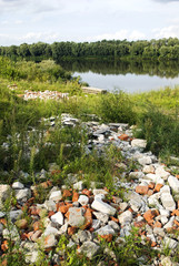 Landfill of building debris on the banks of the river