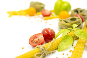 Pasta, spaghetti, tomatoes, basil are on a white background