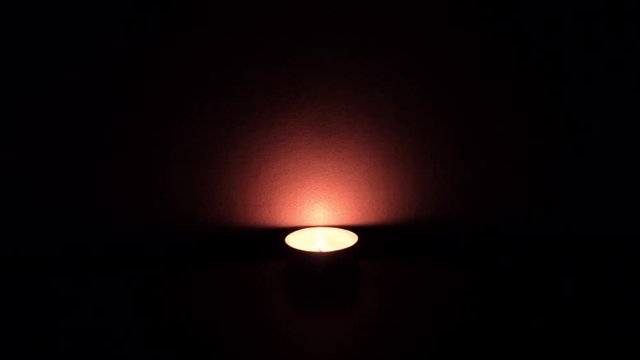 Small candle burning in the dark, 4K.