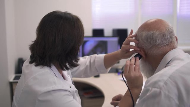 Medical professional tests the ear of an adult man