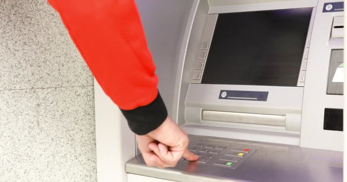 Mans hand enters the amount and presses the ATM control buttons