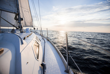 Sailing at sunset. A view from the yacht's deck to the bow and sails. Close-up. Baltic sea, Latvia © Alex Stemmer