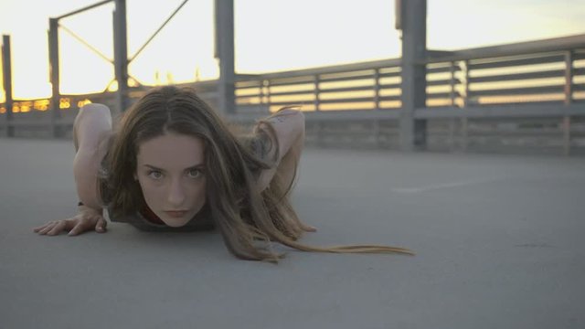 young hip hop dancer falling on the road in order to make dance moves