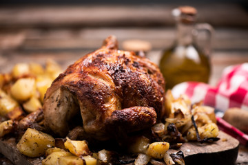 roasted chiken on wooden board with chips