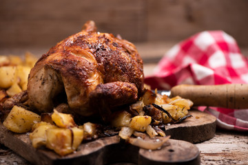 roasted chiken on wooden board with chips