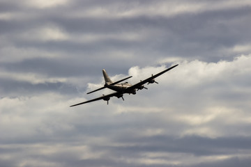 B52 bomber flying away against clouds