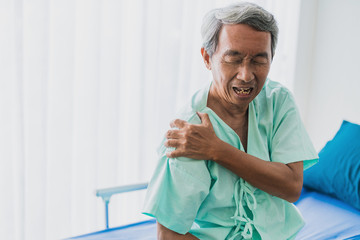 Fototapeta premium pain and shoulder pain senior asian grandfather in patient uniform suffer from body problem health ideas concept