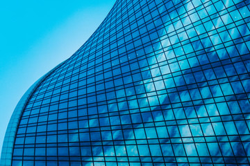 Geometry of a modern business center. Blue background of a glass high-rise skyscraper of a modern...