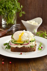 Sandwich with cream cheese, radish, cucumber and poached egg