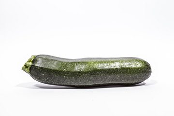 A thick straight zucchini, isolated on a white surface.
