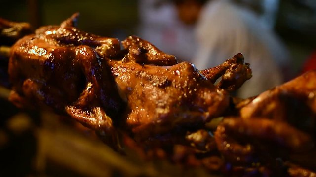 Grilled chicken on a spit, night market in Banlung town. Cambodia. 